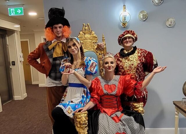 Care home staff dressed up as alice in wonderland characters